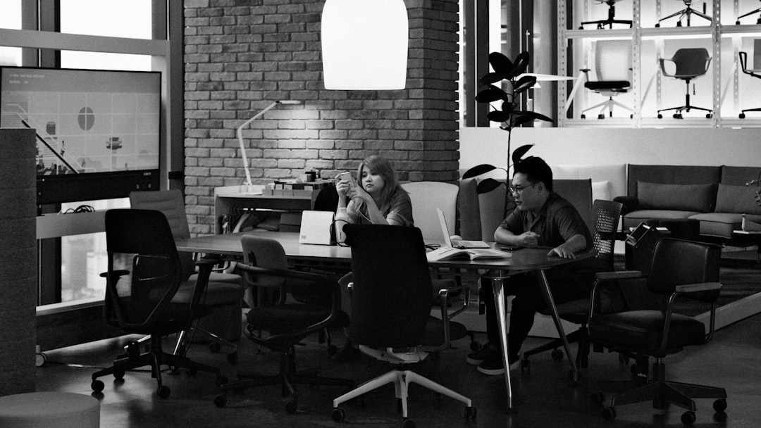 Two people working at a table in an office.